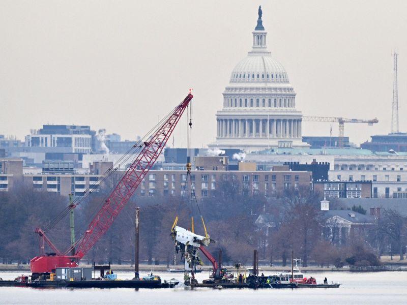 Guindaste remove destroços do avião que caiu no rio Potomac, na capital americana, com o Capitólio ao fundo