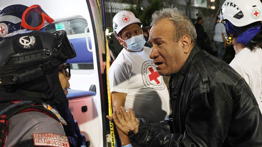 Un hombre habla con un paramédico en un edificio derruido en Los Palos Grandes, Caracas, después de los terremotos que sacudieron a  Venezuela y otras regiones del Caribe el 24 de junio de 2026.