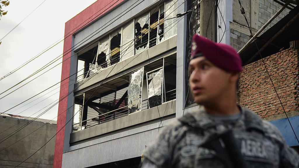 Miembro de la fuerza pública colombiana frente a un edificio afectado por ataques en Cali en agosto de 2025.