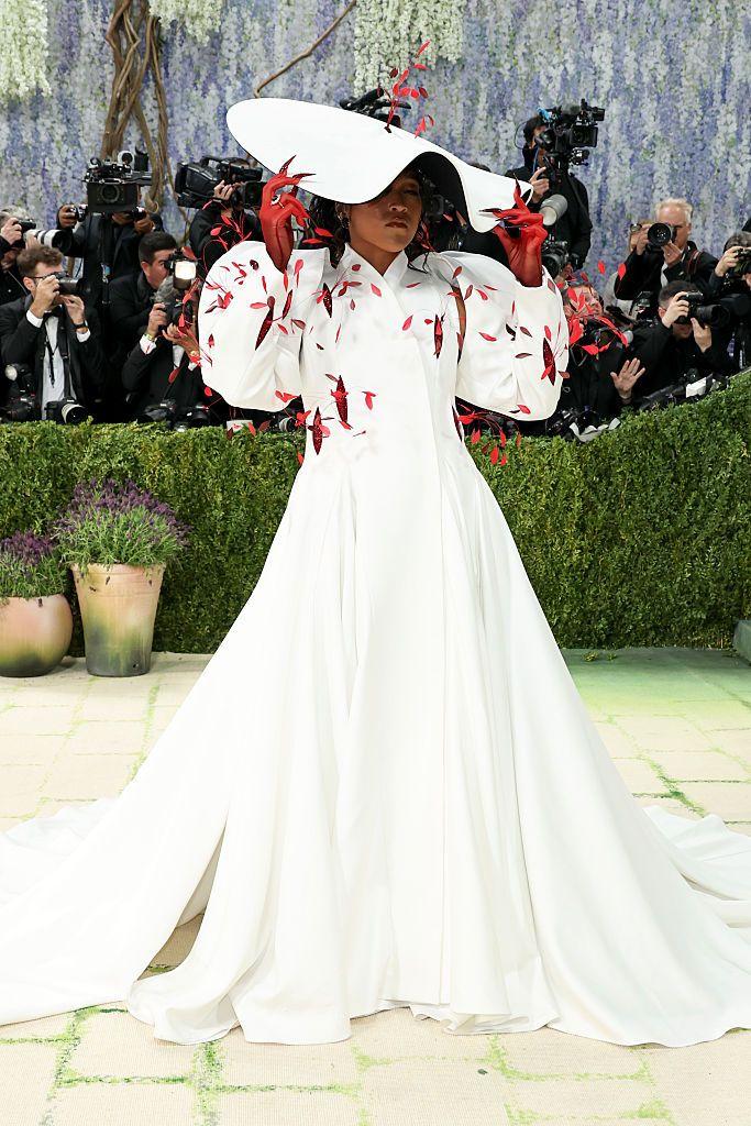 Naomi Osaka u dugom belom kaputu haljini i neobičnim šeširom 