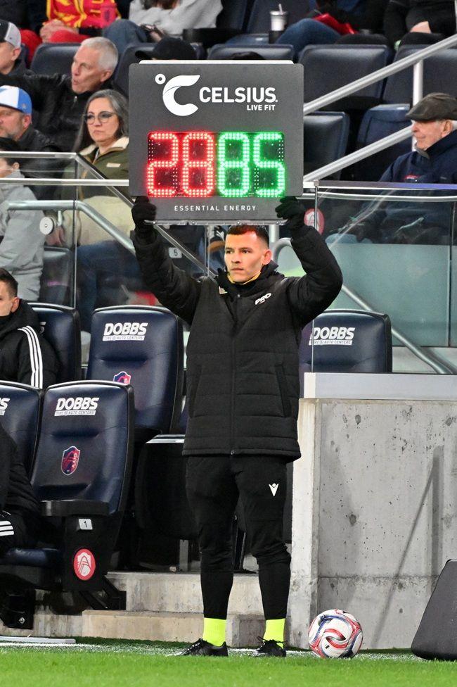 El cuarto árbitro Lorenzo Hernández, vestido de negro, levanta un cartel electrónico que indica una sustitución durante la primera mitad de un partido de la MLS el 7 de marzo de 2026 en St. Louis, Missouri.
