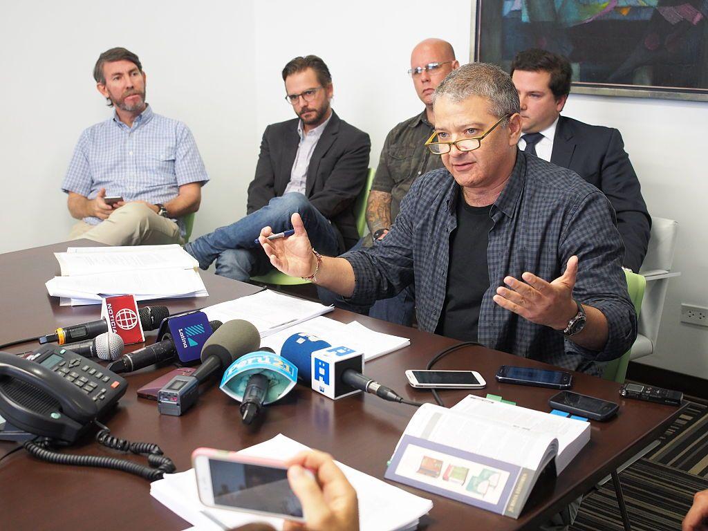 El periodista Pedro Salinas, junto a cuatro hombres, habla en una conferencia de prensa.