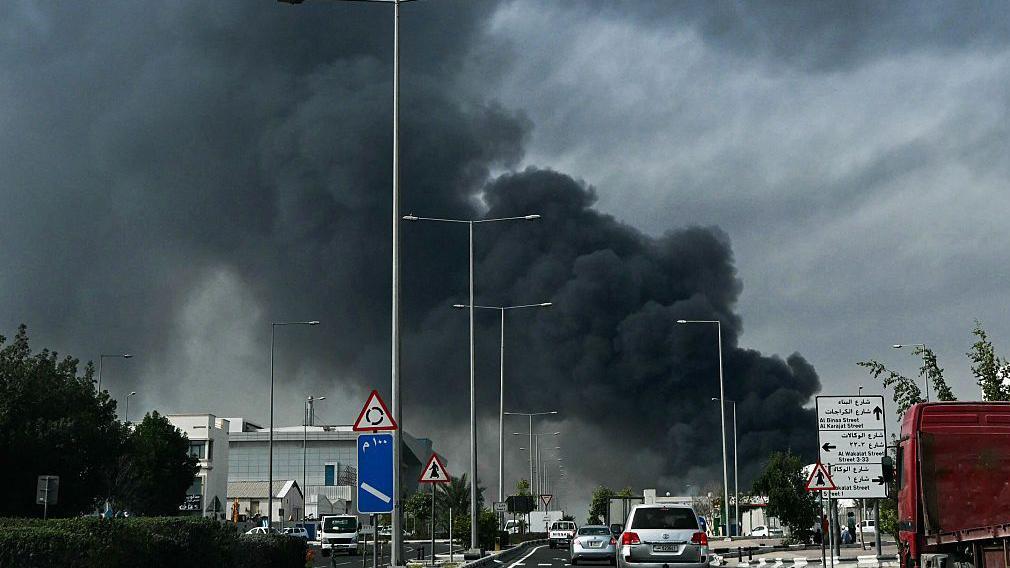 據報道，在多哈工業區發生伊朗襲擊事件後，高速公路的背景中升起了濃烈的深灰色煙霧。