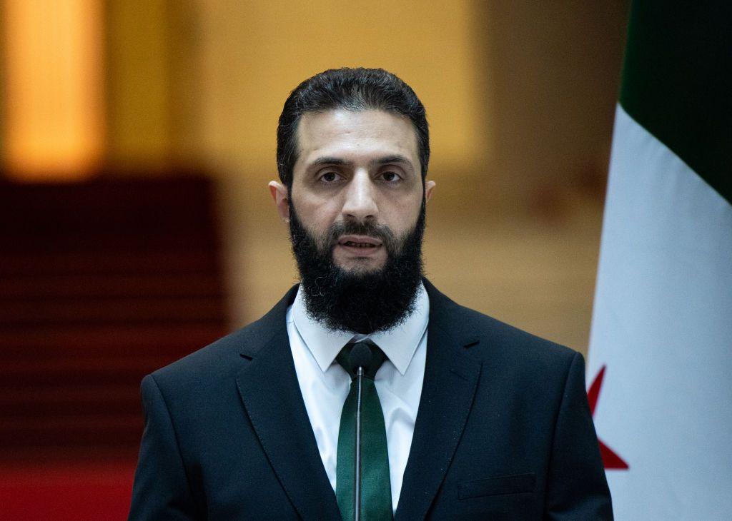 سوريا وإسرائيل تتوصلان لوقف لإطلاق النار 2 الرئيس السوري أحمد الشرع، يرتدي سترة سوداء وقميضاً أبيض وربطة عنق خضراء.