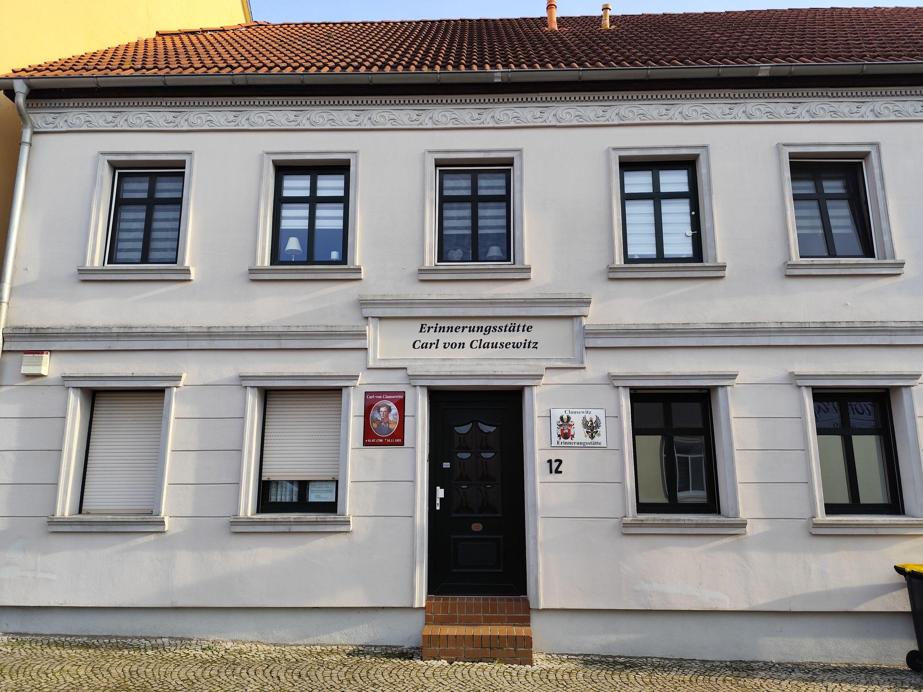 Uma casa branca com o nome de Clausewitz acima da porta