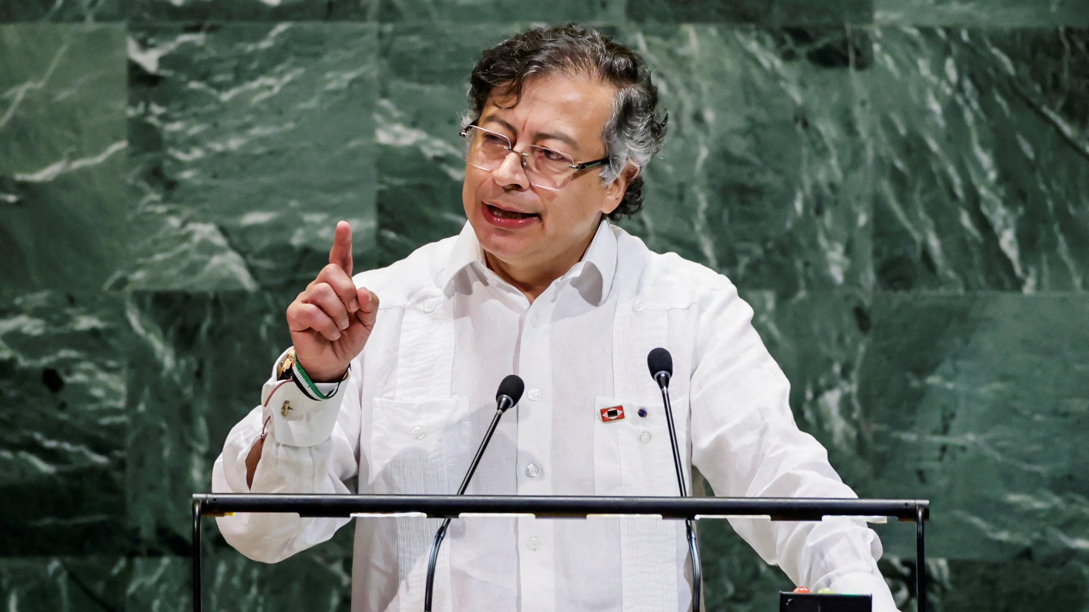 El presidente Petro habla y apunta con su dedo índice mientras da un discurso desde un atril.