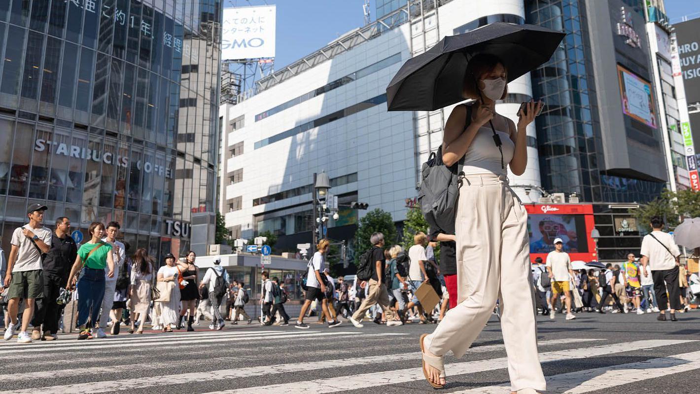 一名女子走在東京的斑馬線上