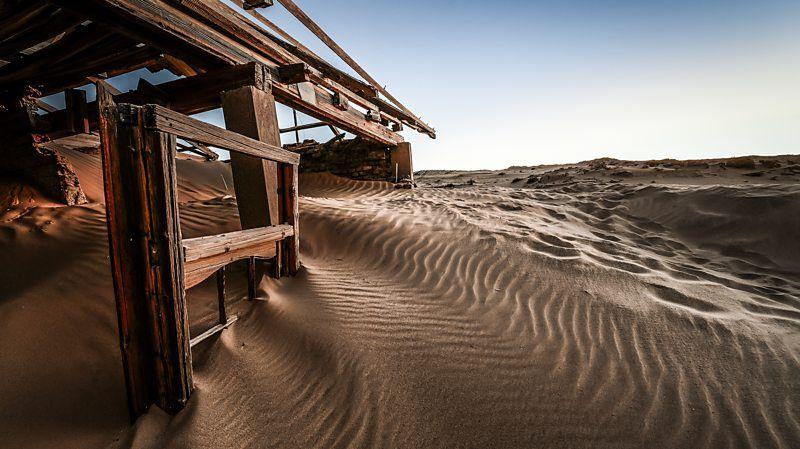 Construção abandonada, sendo engolida pela areia do deserto