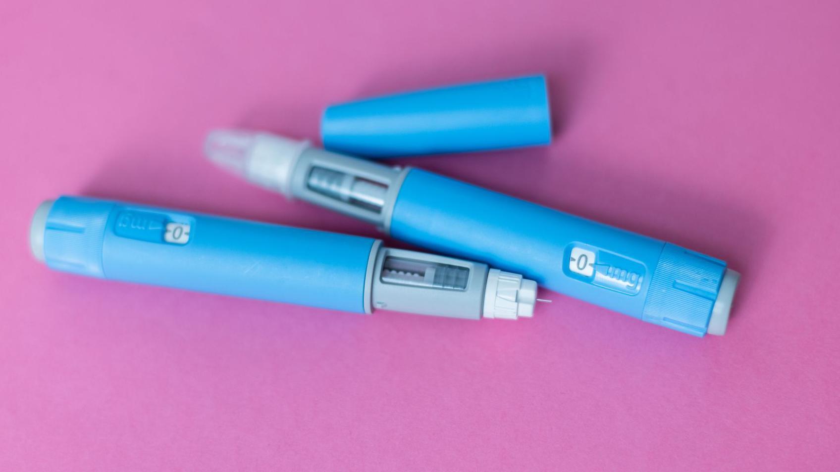 Duas canetas para perda de peso sobre um fundo rosa.