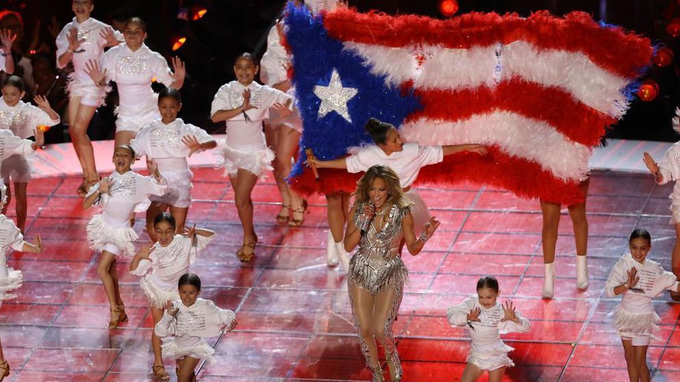 Jennifer Lopez con  la bandera de Puerto Rico la suya llevaba el triángulo azul oscuro.