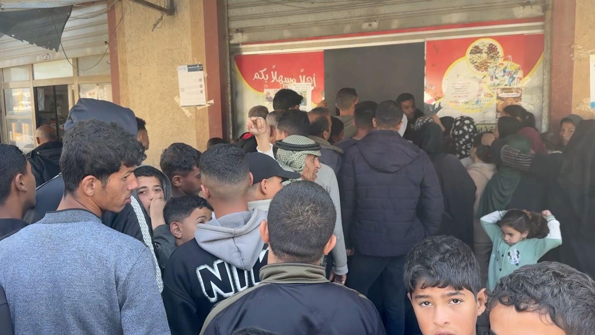 العشرات (بينهم نساء وأطفال) يصطفون أمام مخبز في دير البلح جنوب قطاع غزة