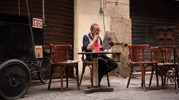 أحد المواطنين يتابع الأخبار من الصحيفة.