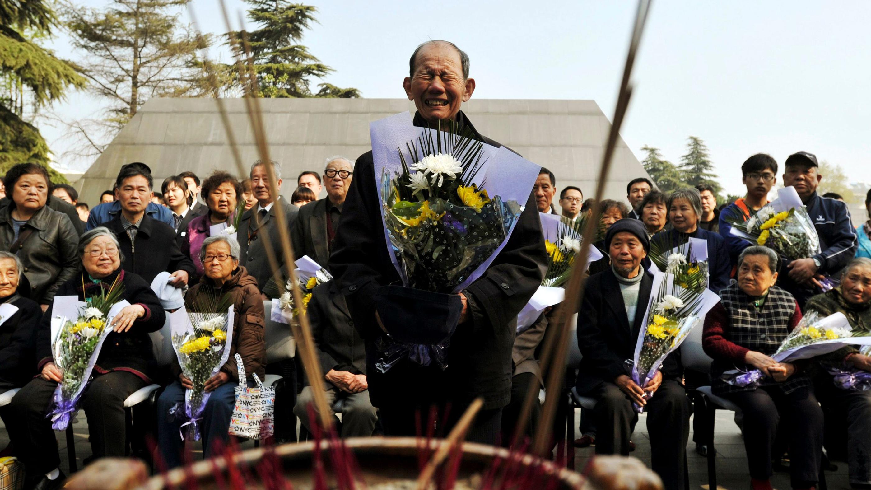 南京大屠殺倖存者佘子清在出席清明節南京大屠殺遇難者悼念儀式時手持菊花痛哭（資料圖片）