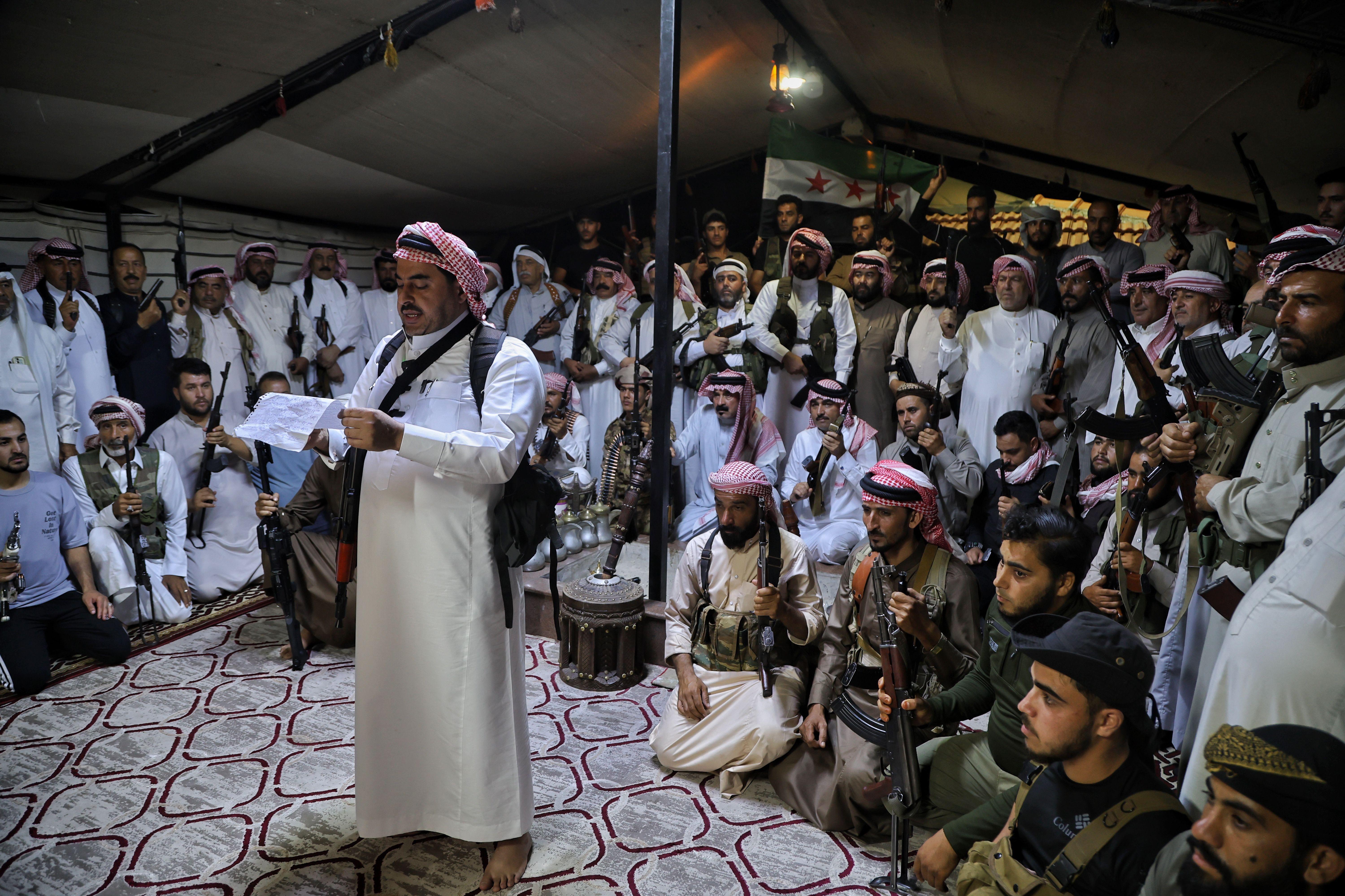 ماذا نعرف عن القبائل السوريّة؟ وما علاقتها بالدولة؟ 4 عضو عشيرة يخاطب مجموعة من المسلحين المتجمعين داخل مقر مجلس القبائل والعشائر السورية في إدلب، سوريا، 18 يوليو/تموز 2025