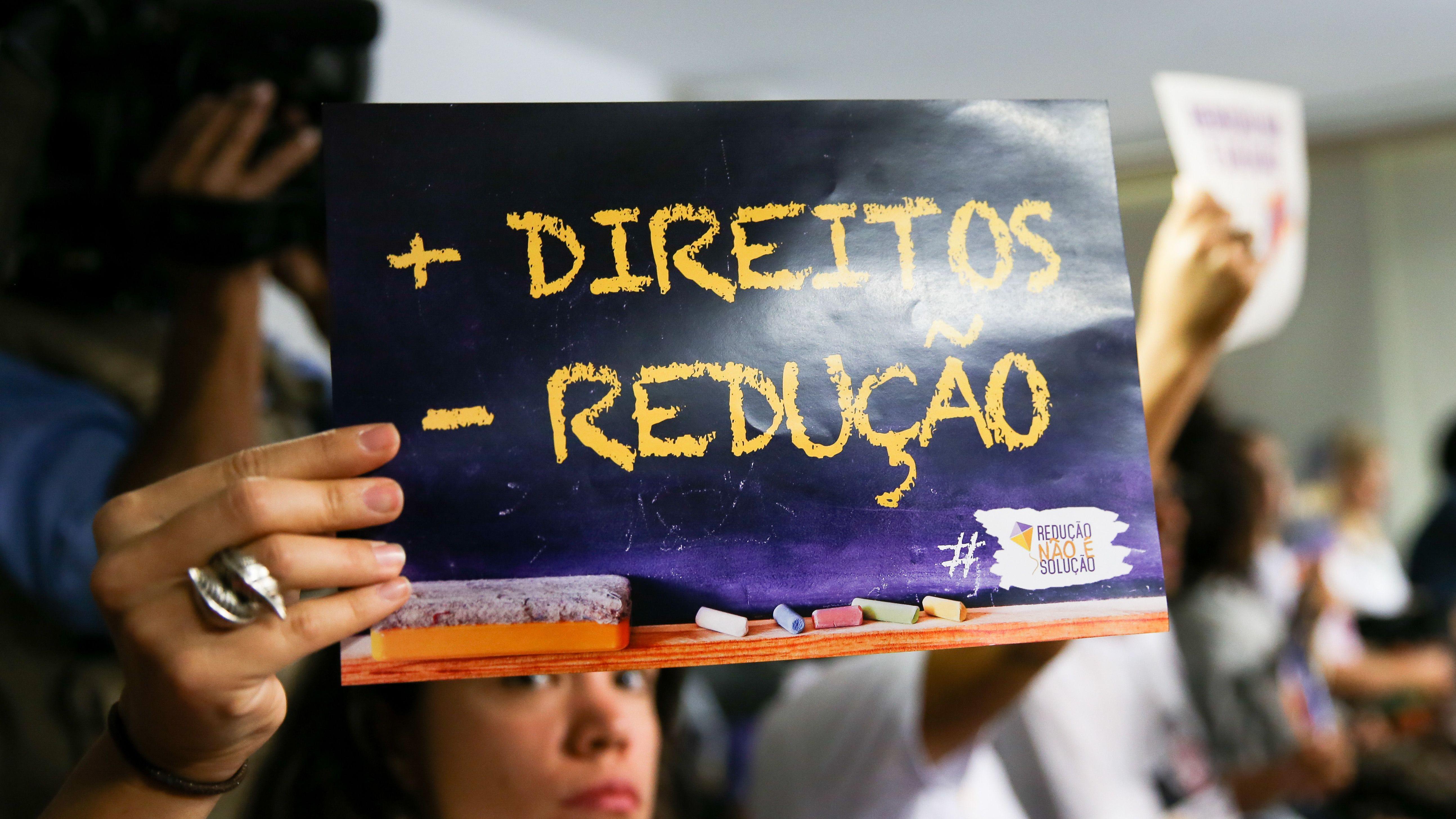 Manifestante contr&aacute;rio &agrave; redu&ccedil;&atilde;o da maioridade penal segura cartaz em que se l&ecirc; 