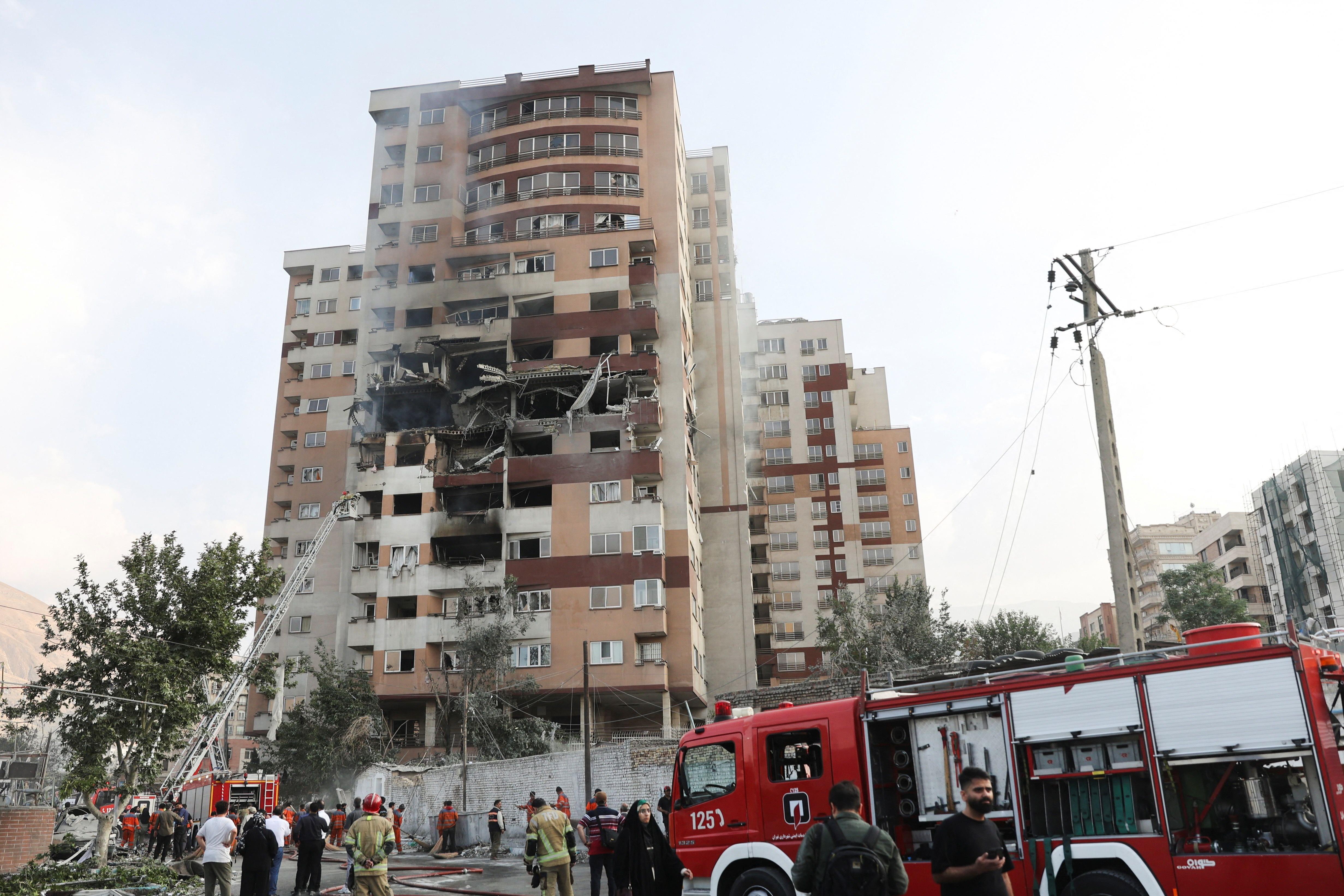 Bomberos trabajan en el lugar de un edificio dañado