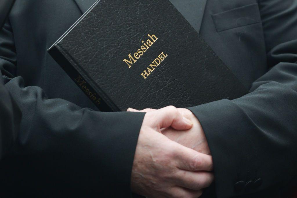 Un cantante sostiene una partitura del Mesías.