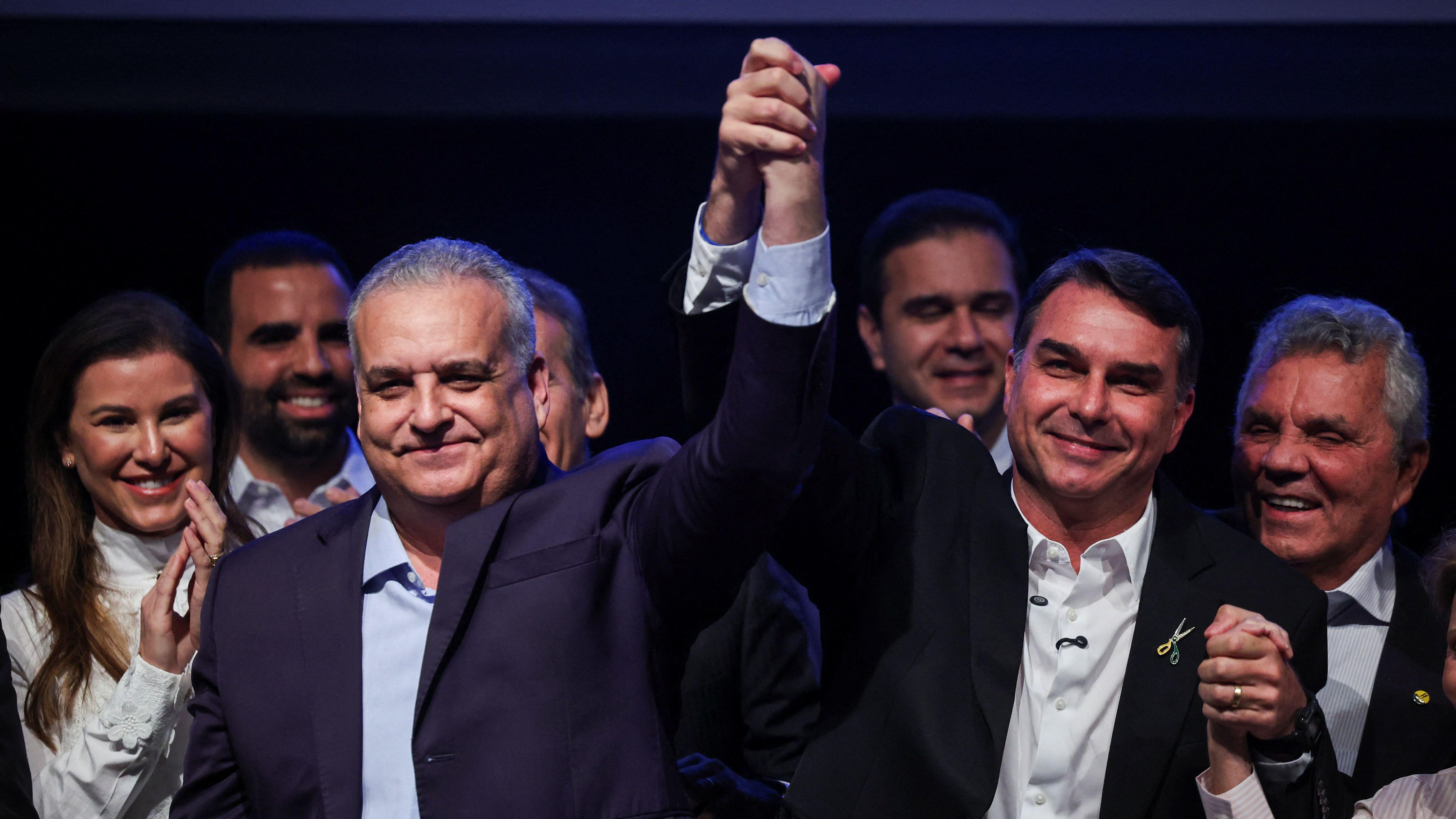 Alfredo Gaspar e Fl&aacute;vio Bolsonaro de m&atilde;os dadas e erguidas