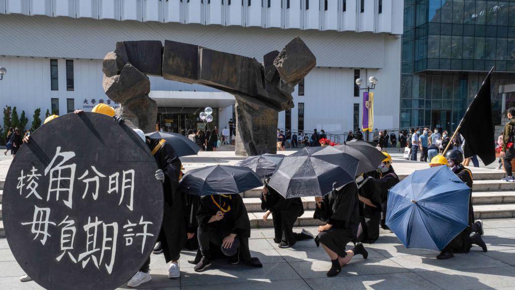 2020年11月19日，香港中文大學畢業生佩戴口罩，高喊口號。