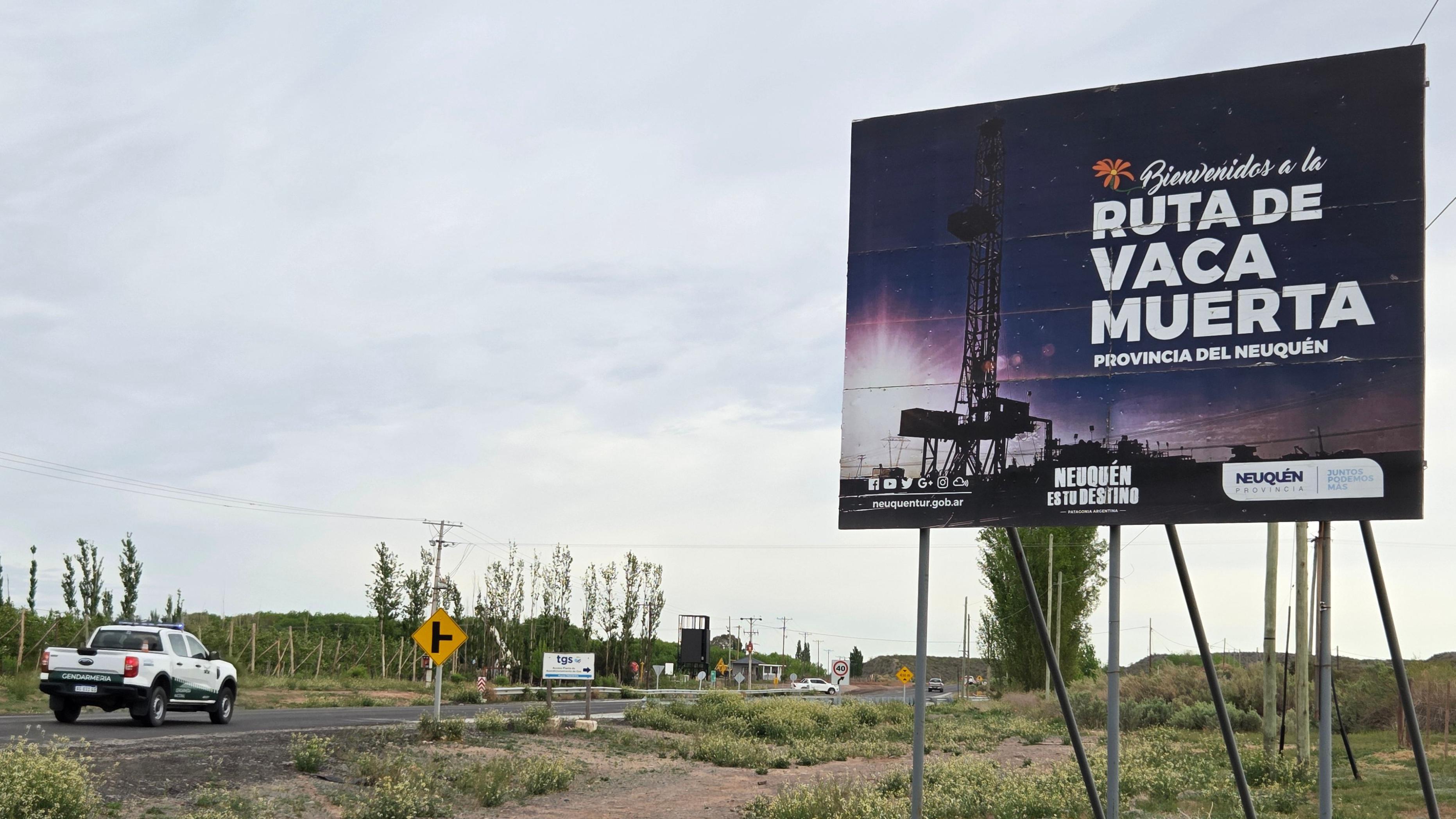 Ruta por donde pasa una camioneta y hay un cartel que dice Vaca Muerta.
