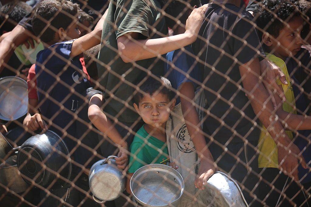 Una organización benéfica distribuye comida caliente a palestinos que enfrentan dificultades para acceder a los alimentos debido a los continuos ataques de Israel en la Franja de Gaza el 13 de julio de 2025.