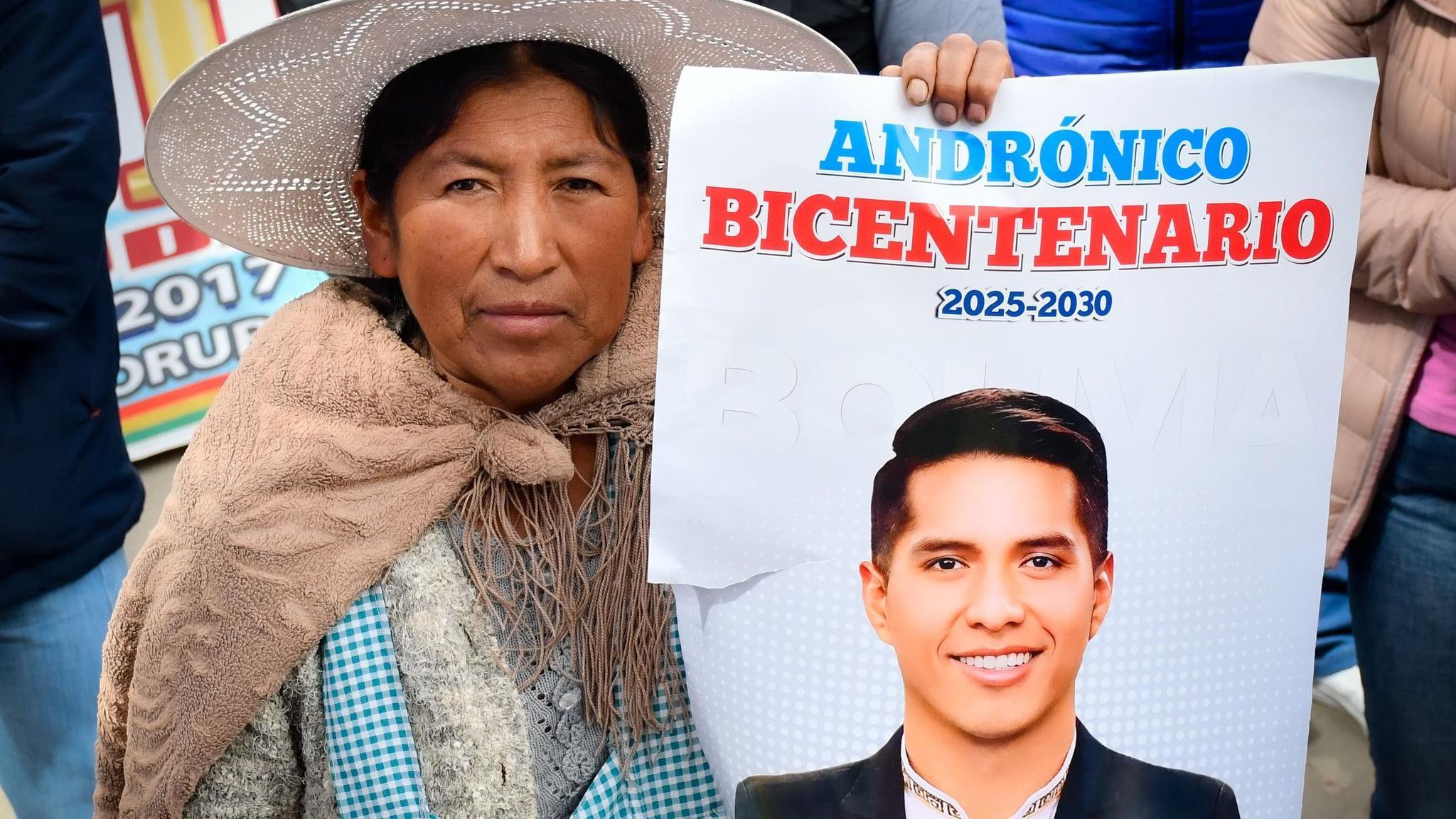 Una mujer sostiene un afiche con la cara de Andrónico Rodríguez. 