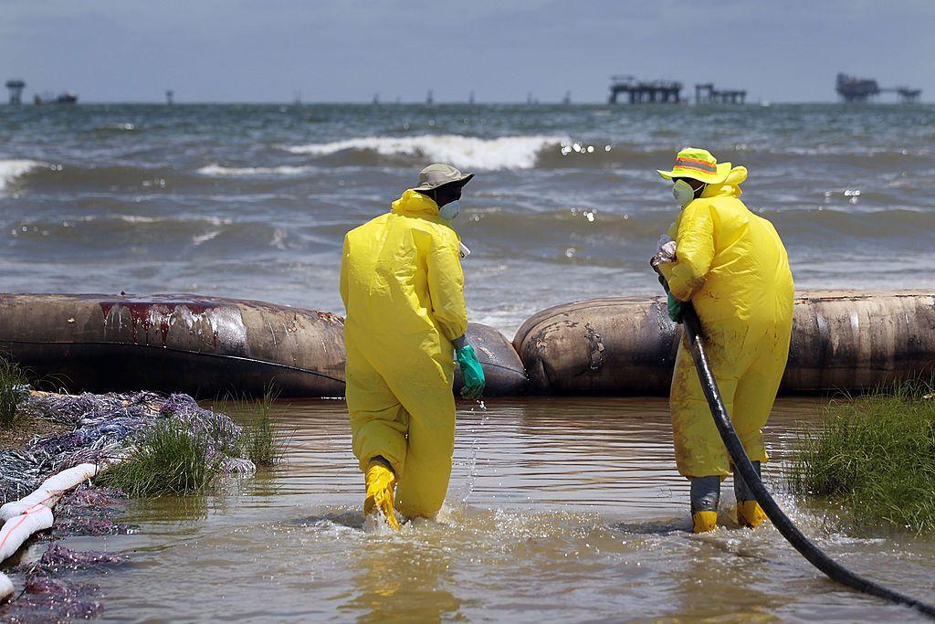 Hombres limpian una playa tras el Deepwater Horizon