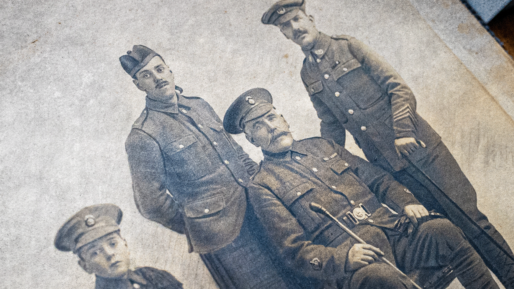 Una foto en sepia de un grupo de cuatro hombres con uniforme militar.