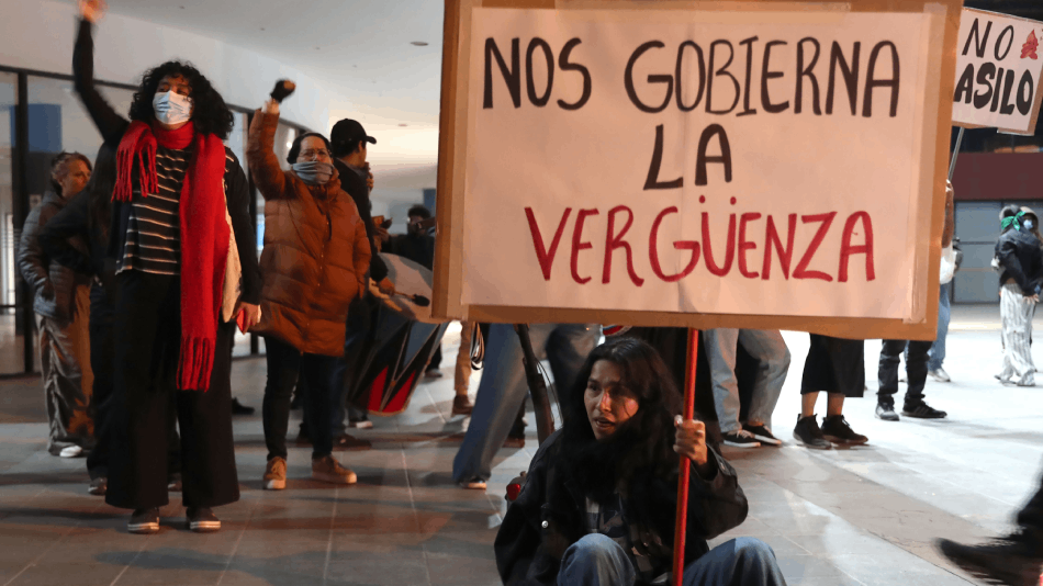 Un manifestante sostiene un cartel que dice "Nos gobierna la verguenza" protestando contra la presidenta peruana Dina Boluarte.