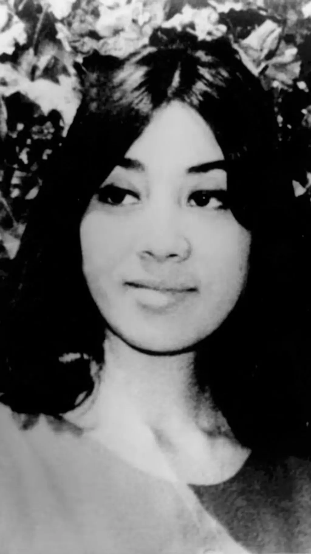 Foto en blanco y negro del rostro de una mujer de pelo negro.
