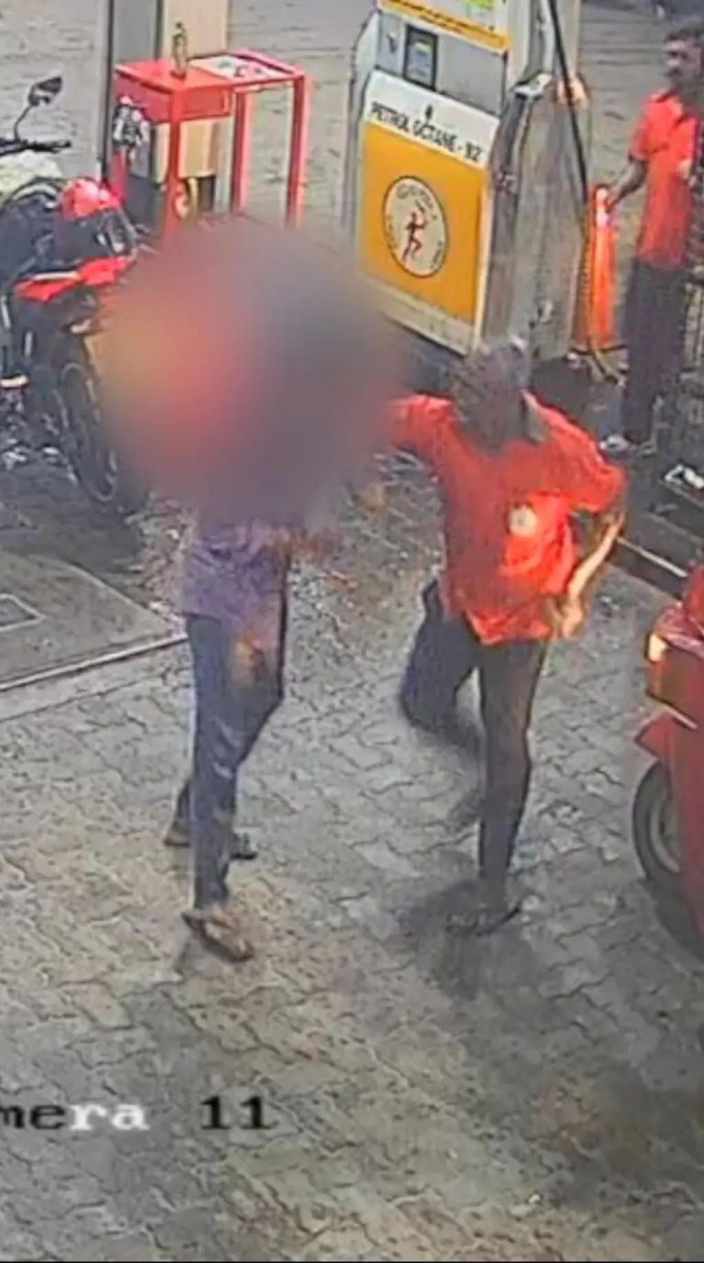 ඉන්ධන පිරවුම්හලක සිටින රතු පාට කමිසයක් ඇඳ සිටින අයෙකු තවත් පුද්ගලයෙකුව තල්ලු කරන අකාරය පෙනේ.
