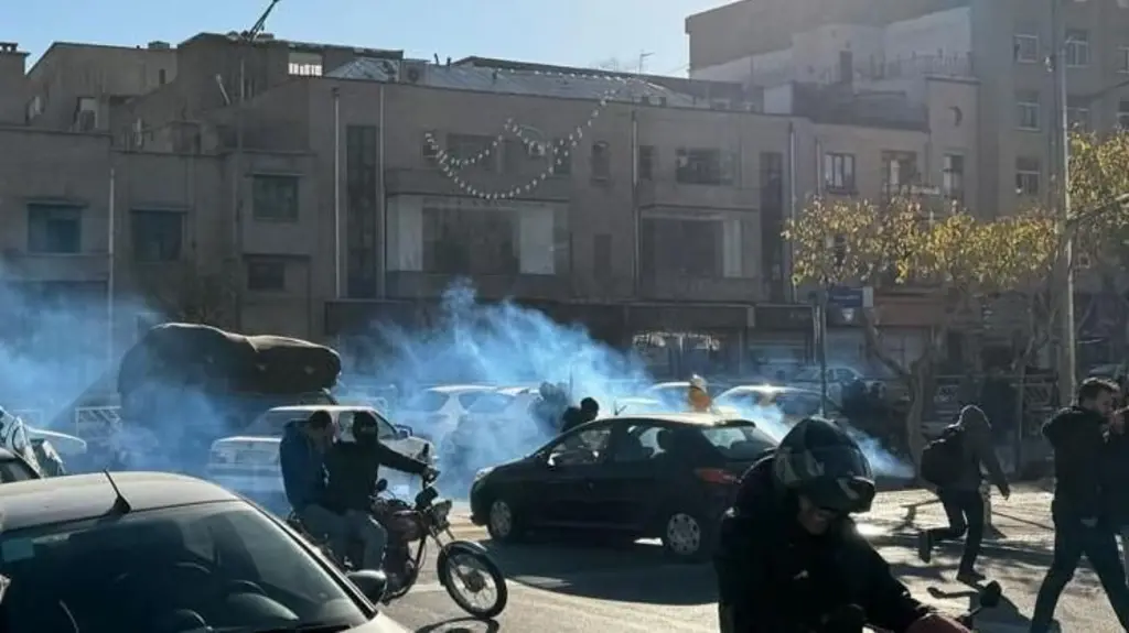 Pessoas na rua em meio a uma fumaça