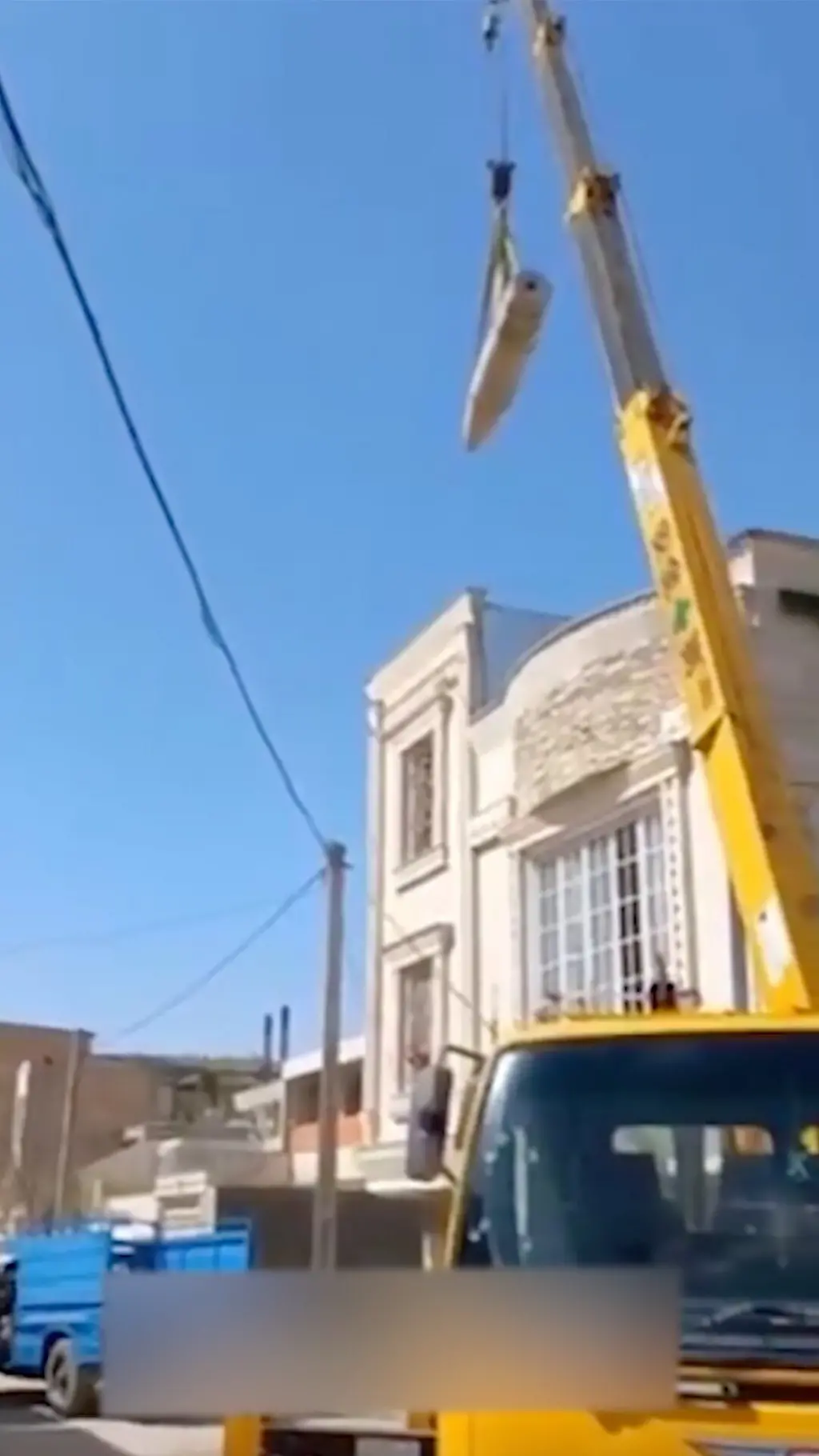 පුපුරා නොගිය රොකට් හැඩති බෝම්බයක් දොම්බකරයකින් ඔසවන අයුරු මෙහි පෙනේ.