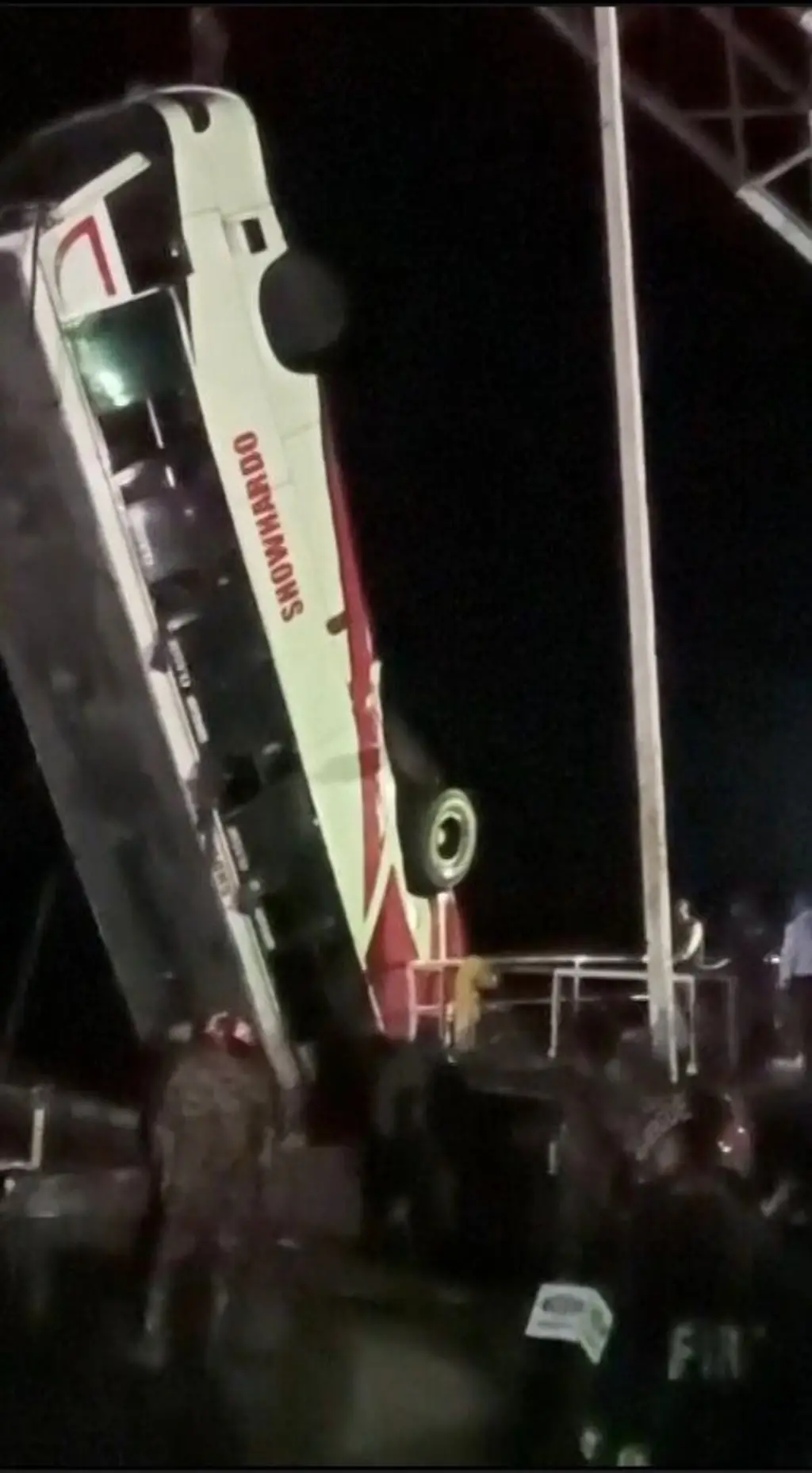 සුදු පැහැති බස් රථයක් දොම්බකරයකින් ඔසවන අයුරු පෙනේ.