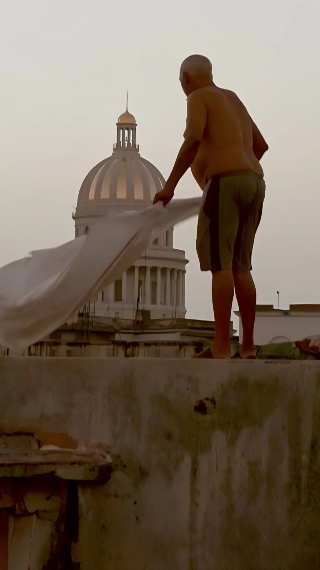 Hombre de pantalones cortos sin camiseta en una azotea
