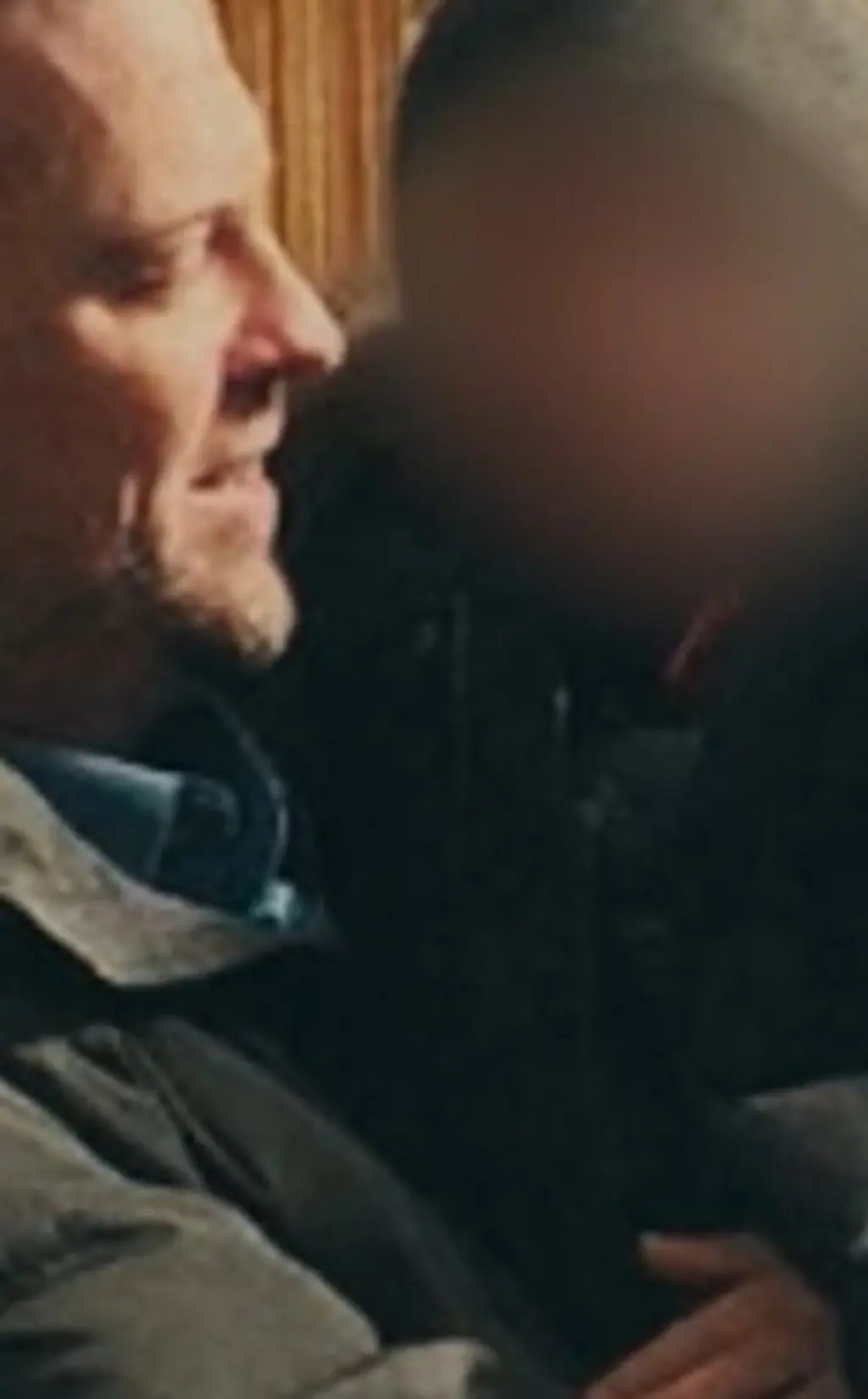 Menino (com rosto borrado) no colo de policial