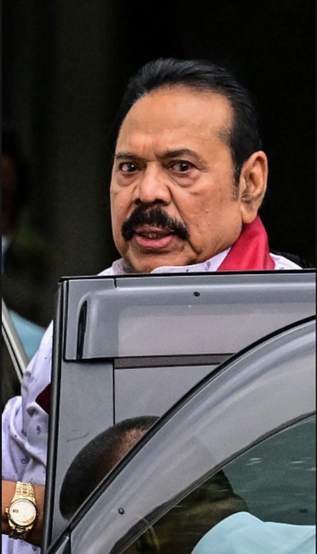 මහින්ද රාජපක්ෂ වාහනයකට නගින අවස්ථාවක් පෙනේ.