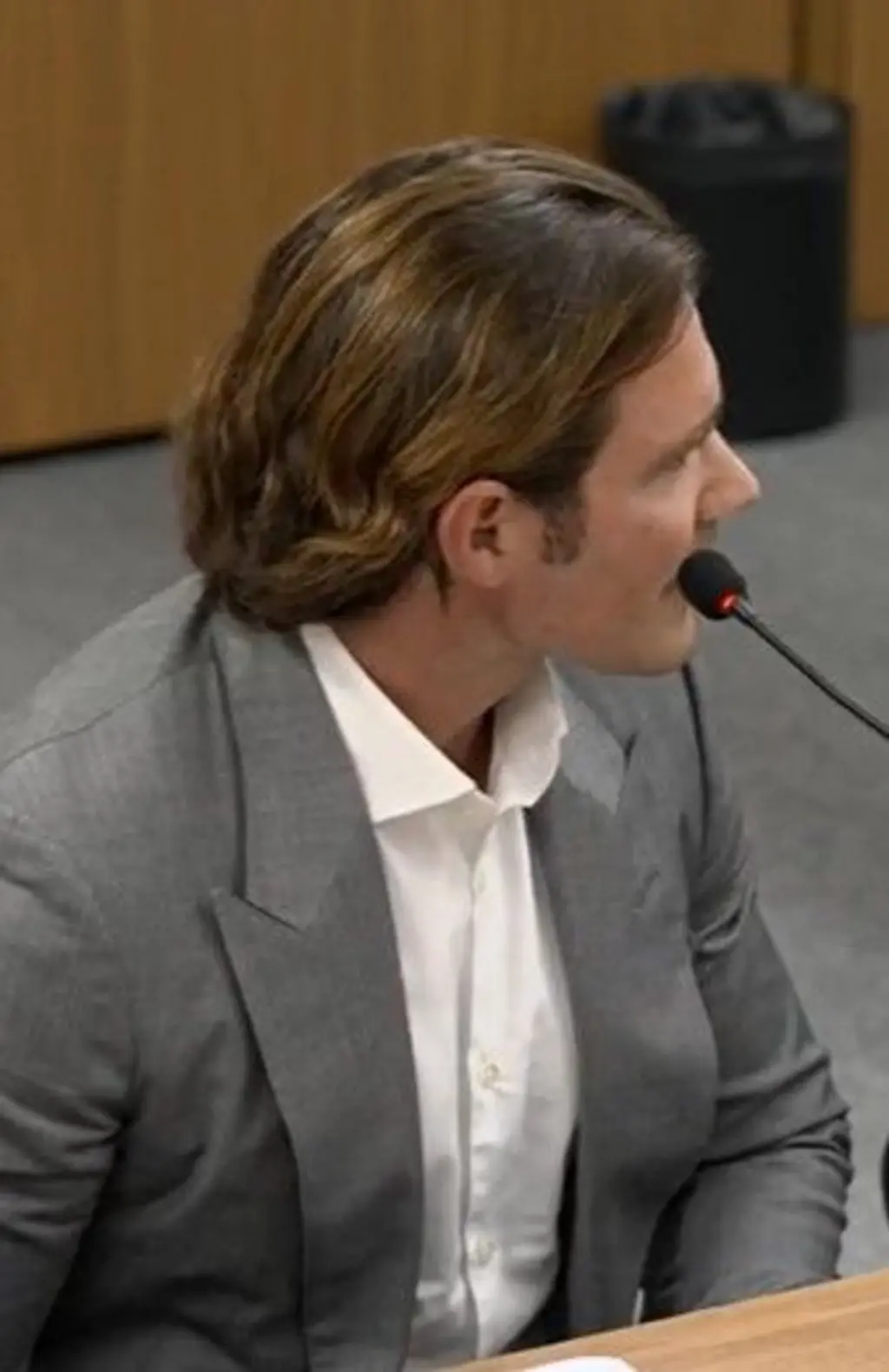 Daniel Vorcaro de perfil falando em um microfone enquanto presta depoimento à Polícia Federal