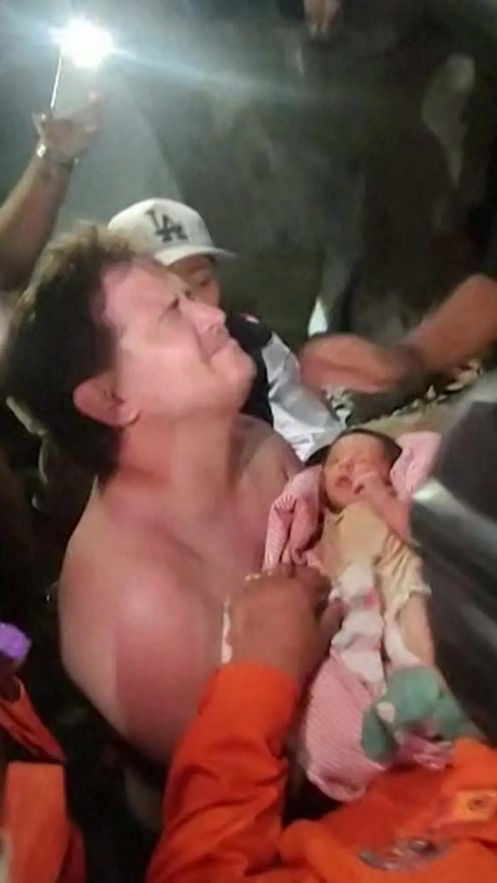 Un hombre emocionado carga un bebé recién nacido
