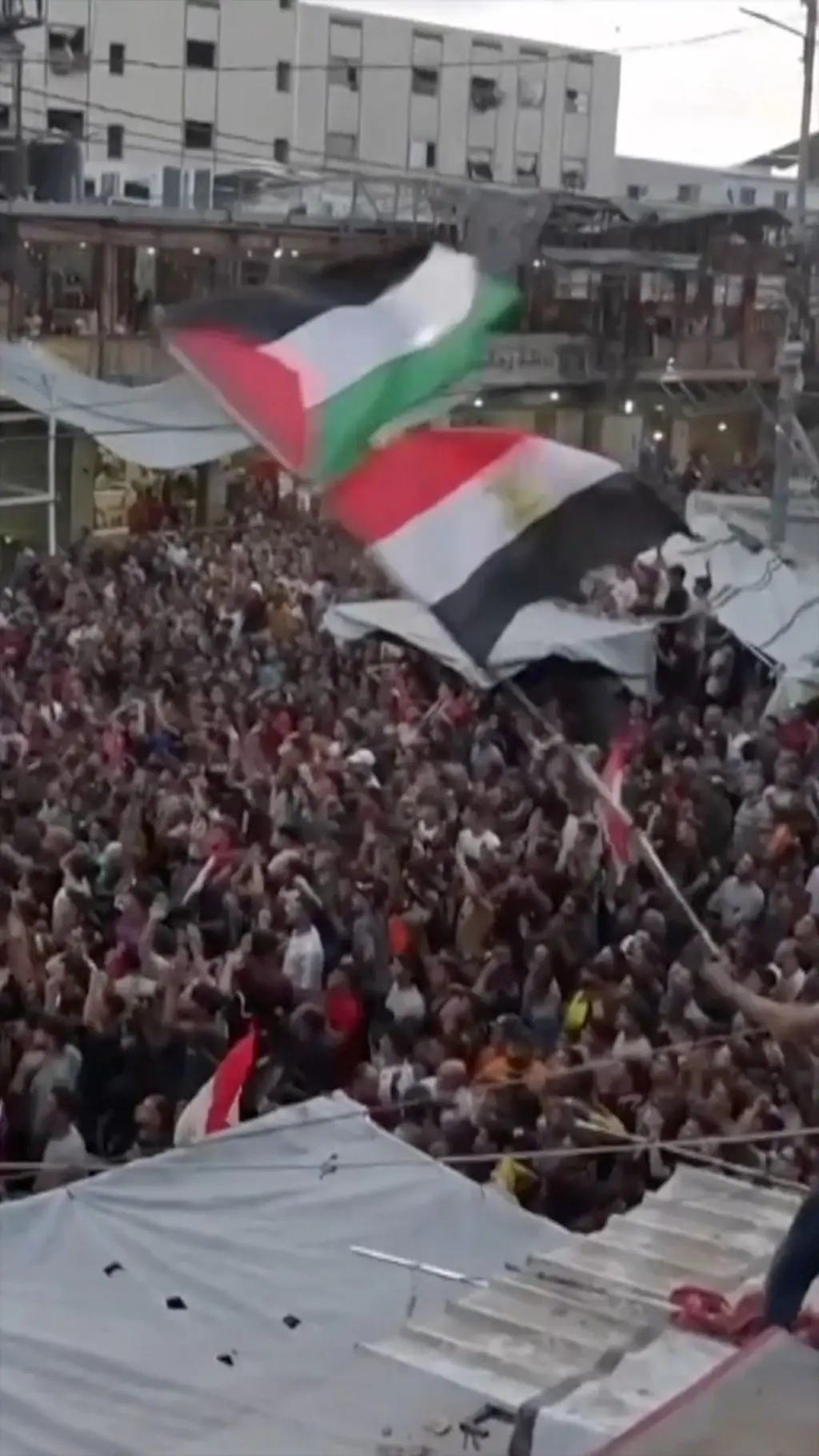 Ғазода кўплаб одамлар футбол томошо қилиш учун йиғилган. Расм ўртасида эса бир киши Фаластин ва Миср байроқларини ҳилпиратиб турибди.