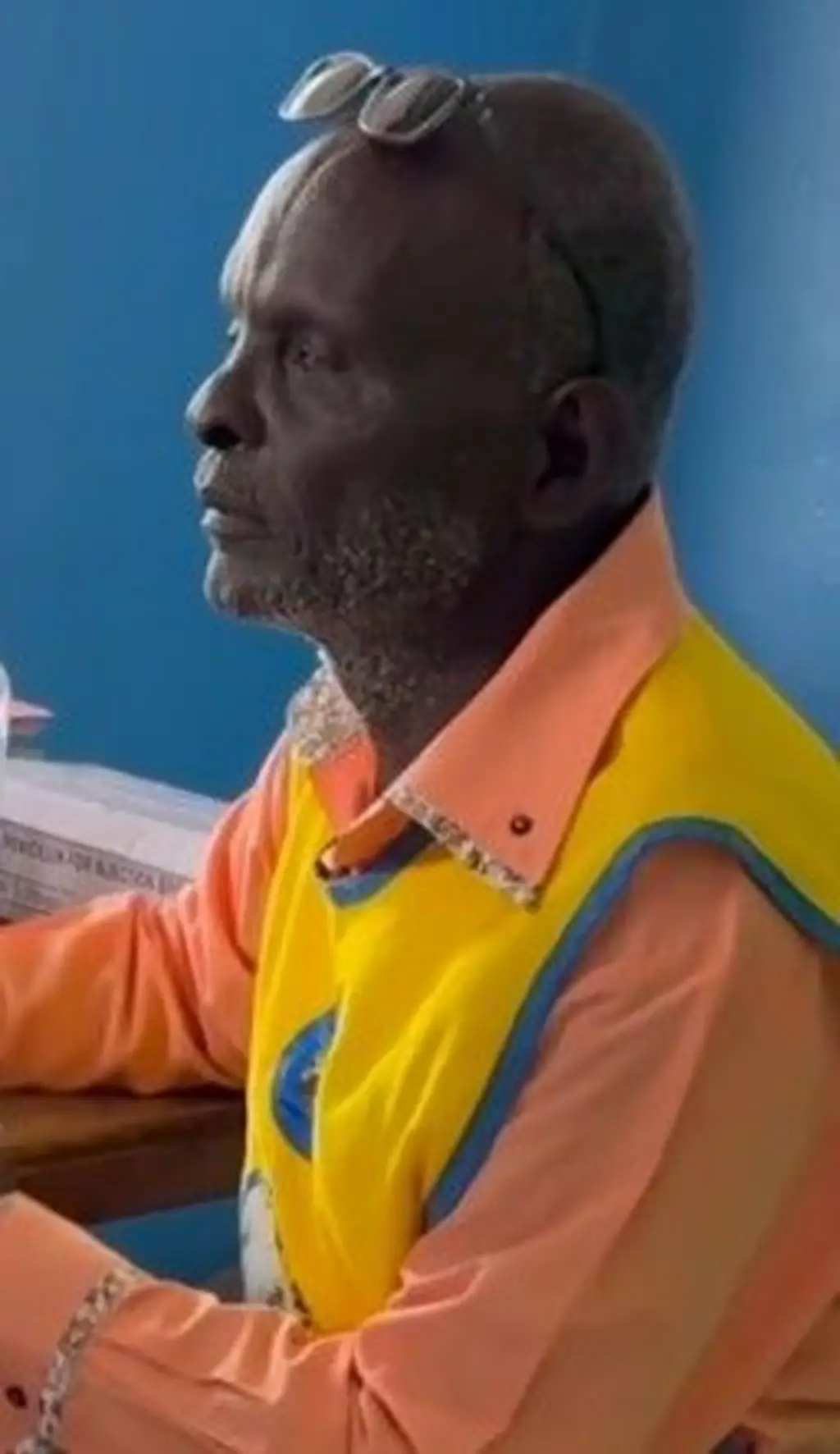 Um homem negro usado uma camisa laranja