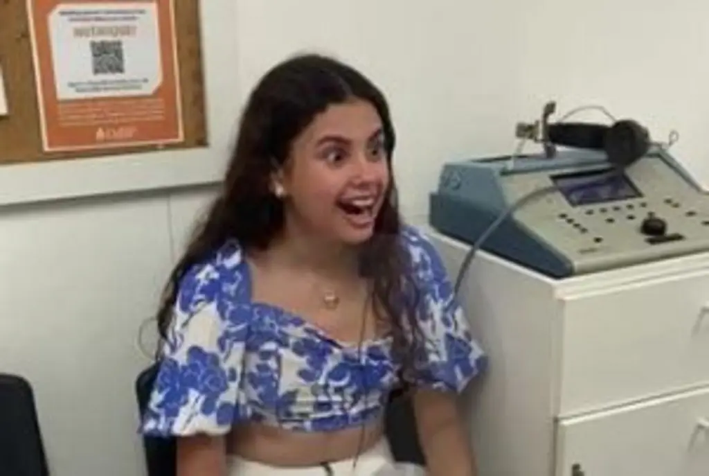 Uma menina em um consultório olhando para frente e sorrindo