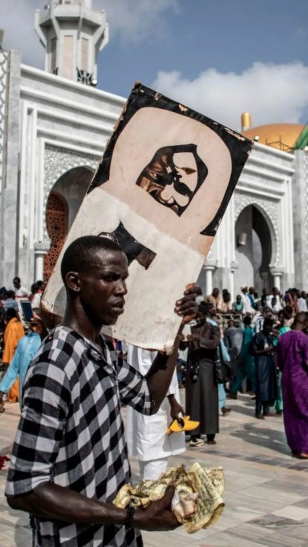 Fidèle qui porte sur son épaule une photo de Cheikh Ahmadou Bamba