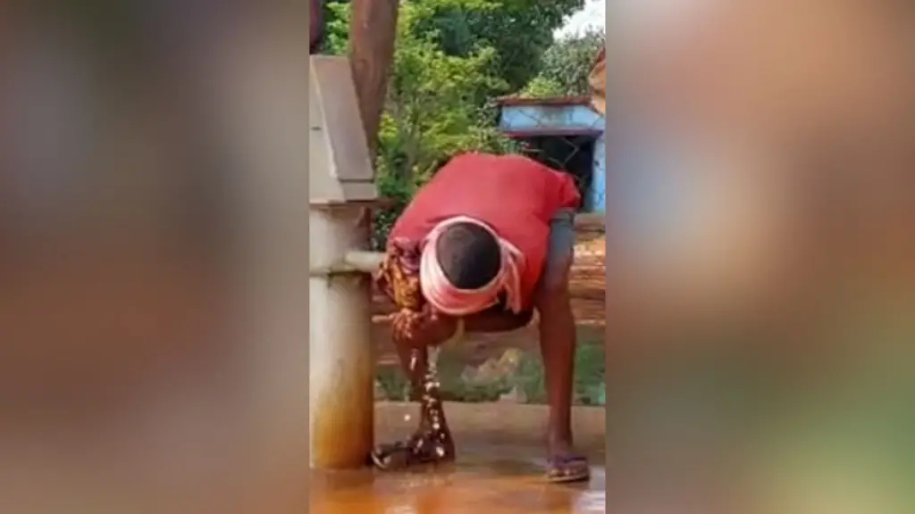 हैंडपंप से पानी पीता शख़्स