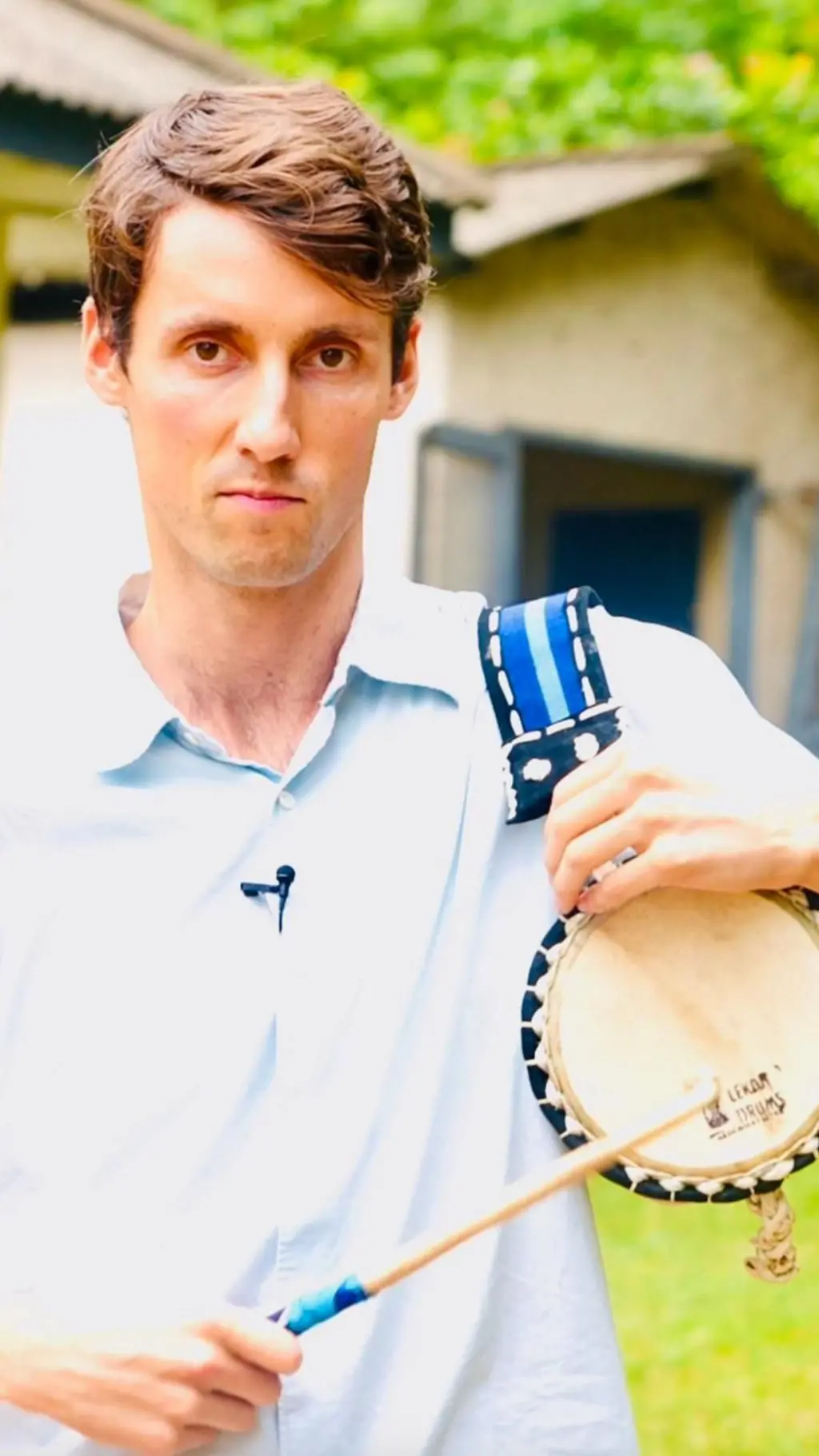 Ọkunrin alawọ funfun to gbe ilu dani, to si n wo ẹrọ ayaworan