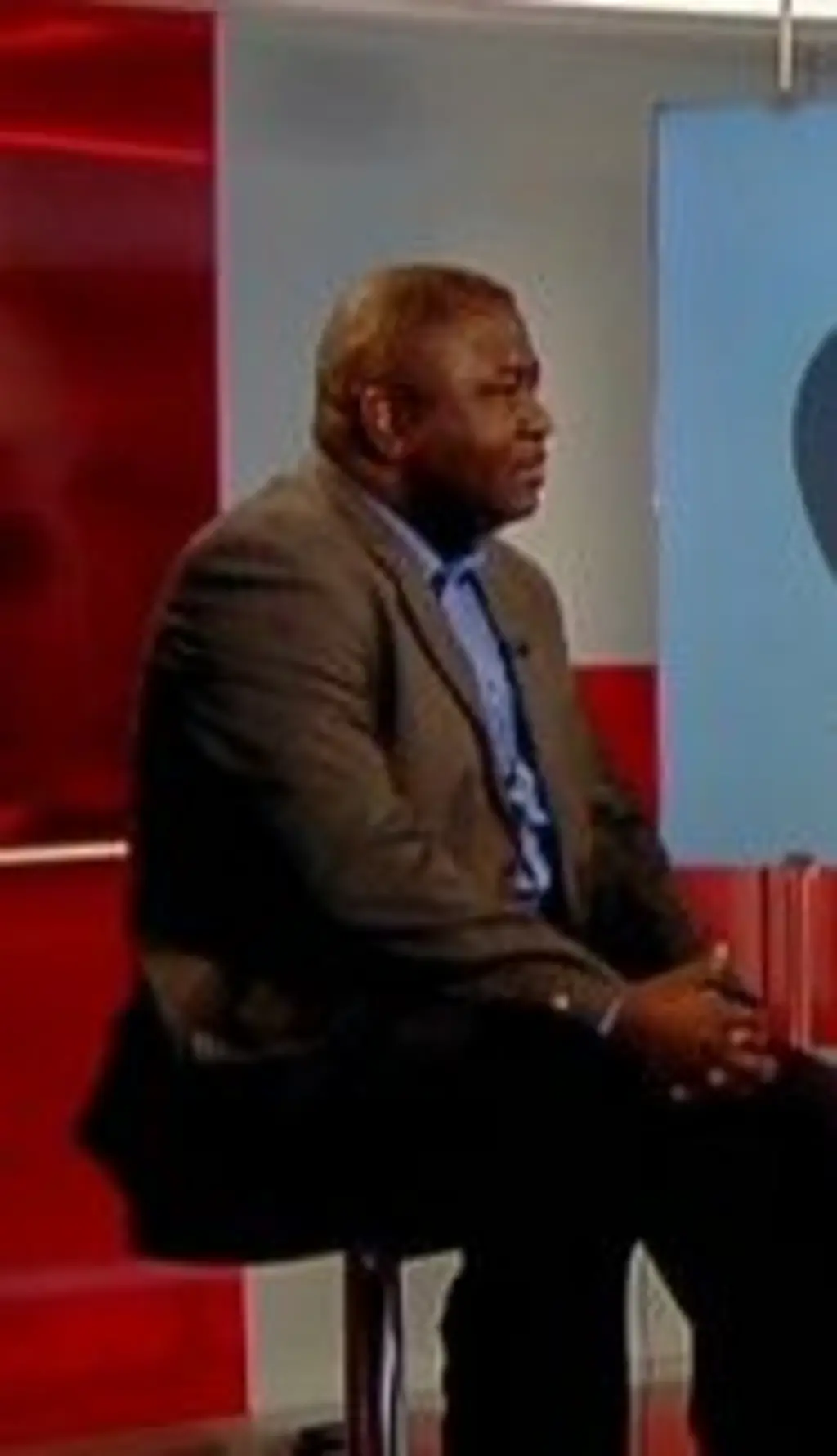 Um homem negro sentado para uma entrevista