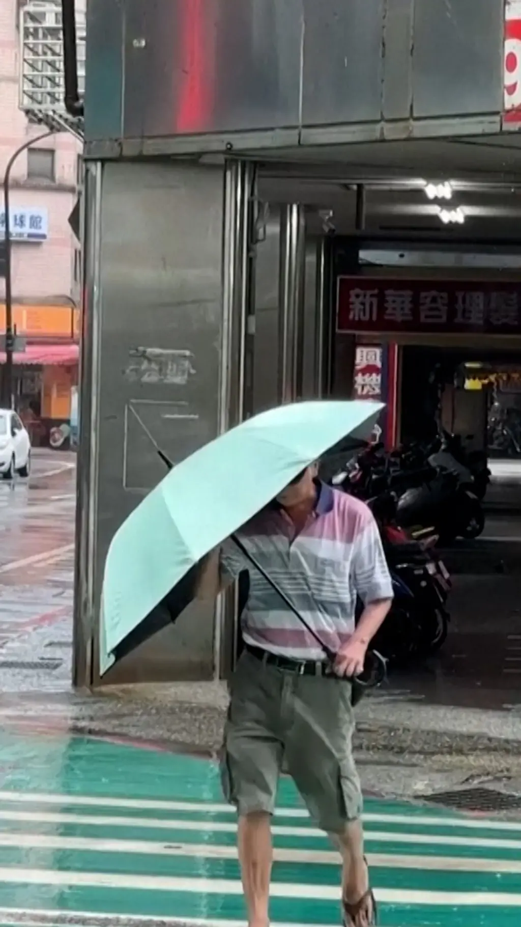 路人拿傘在斑馬線上行走