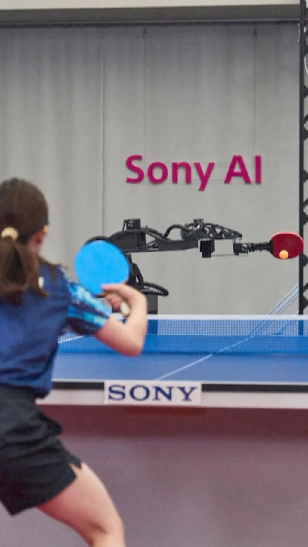 Devojčica i robot igraju stoni tenis