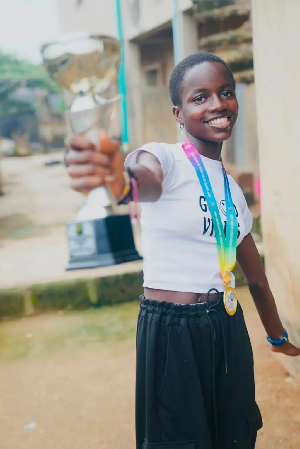 Girl hold award as she smile into di camera