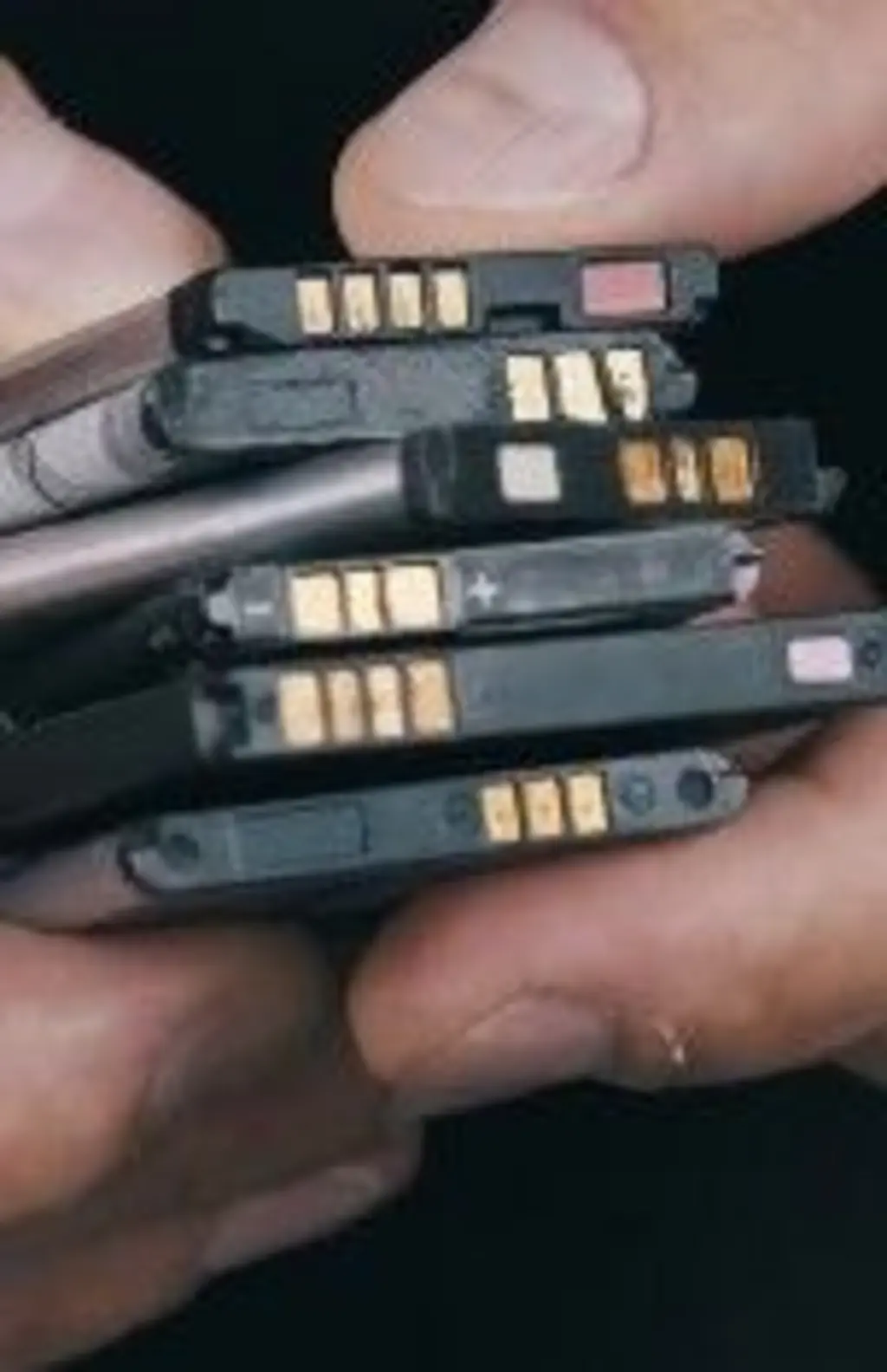Uma mão segurando baterias de celular